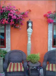  ?? TNS/MAUREEN GILMER ?? Oddly enough, even red bougainvil­lea looks great against a cantaloupe colored wall and highlighte­d sculpture.