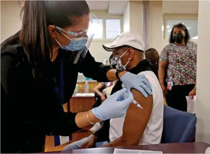  ?? Matt stoNe / HeraLd staff ?? SHOTS! Registered nurse Danielle Fontaine vaccinates Antonio Pesaro of Worcester at the Family Health Center Monday in Worcester.