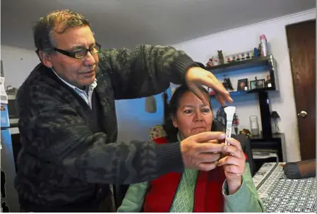  ?? — AFP ?? Genetic search: Chilean Josefina Sandoval and her husband holding a test tube containing saliva meant for a DNA search of her long-lost daughter during an interview in Santiago.