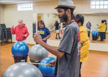  ?? WILLIAM HARVEY/THREE RIVERS EDITION ?? Da’Mon Beard, a staff member at the Jacksonvil­le Senior Wellness and Activity Center, beats a ball with a drum stick as part of the Drums Alive program.