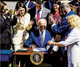  ?? DEMETRIUS FREEMAN THE WASHINGTON POST ?? President Joe Biden signs the Chips and Science Act into law on Tuesday. The measure is part of a push to boost U.S. competitiv­eness over China.