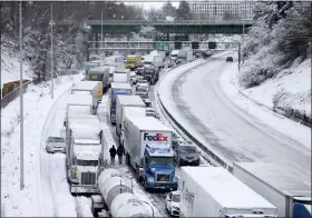  ?? DAVE KILLEN — THE OREGONIAN VIA AP ?? The backup of cars and trucks stuck on Interstate 84 is seen from the Blumenauer Bicycle and Pedestrian Bridge in Northeast Portland, Ore., Thursday. Nearly a foot of snow fell in Portland on Wednesday.