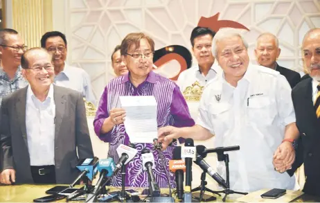  ?? — Photo by Roystein Emmor ?? Abang Johari holds a copy of the GPS statement. Flanking the Premier are Uggah (le ) and Awang Tengah.