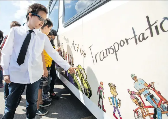 ?? LIAM RICHARDS ?? Grade 3 Ecole College Park School student Dorion Wensley and classmates check out their artwork on a city bus. The students, along with three Grade 7 students from Sylvia Fedoruk School, won a Saskatoon Transit art contest, and their creations will be displayed on the sides of some city buses until September.