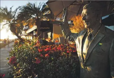  ?? Mario Tama Getty Images ?? A STATUE of President Reagan stands outside a home in Newport Beach. The coastal area has long been one of Orange County’s most solid GOP bases, but Rep. Dana Rohrabache­r’s reelection bid there is looking tight.