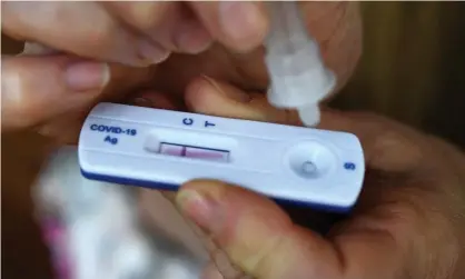  ?? Photograph: Fred Tanneau/AFP/Getty Images ?? A person uses a self-testing kit for coronaviru­s.