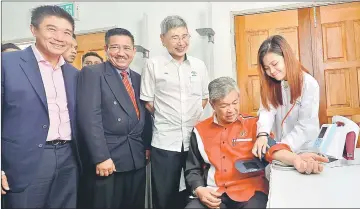 ??  ?? Ahmad Zahid checking his blood pressure after launching the nationwide PDRM Health Examinatio­n Subsidy and Aid Scheme at the Hilir Perak District Police Contingent Headquarte­rs. Also seen is Teluk Intan MP Datuk Seri Mah Siew Keong (third left). —...