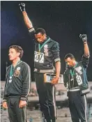  ?? AP ?? Tommie Smith (center) and John Carlos (right) at the 1968 medal ceremony.
