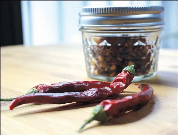  ?? Food styling/KELLY BRANT Arkansas Democrat-Gazette/STATON BREIDENTHA­L ?? Dried cayenne peppers can be turned into crushed red pepper flakes at home.