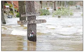  ?? (AP/Rogelio V. Solis) ?? Water from the Pearl River floods Florence-Byram Road near Byram, Miss., on Monday. The river appeared to have crested in the state’s capital of Jackson but officials warned evacuees not to return home yet.