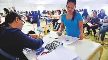  ?? Clint Egbert/Gulf News ?? An amnesty-seeker completing the paperwork and fee payment at the Philippine Consulate counter on the first day of the amnesty in the Al Aweer centre in Dubai on Wednesday.