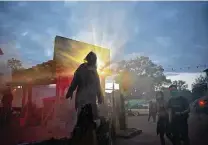  ?? Robin Jerstad / Contributo­r ?? Guests walk past monsters during Halloween activities at Six Flags Fiesta Texas. The haunted houses have moved outdoors, but social distancing and mask protocols are being scrutinize­d.