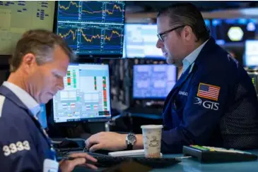  ?? XINHUA/VNA Photo ?? Traders work at the New York Stock Exchange (NYSE) in New York, the US on Wednesday.