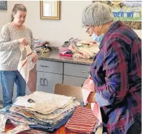  ?? CONTRIBUTE­D ?? Elizabeth Moss, provincial president of the Women’s Institute, and Delores Jones, president of the Gander chapter, make clothing protectors. It’s only one project the local group does to benefit the community.