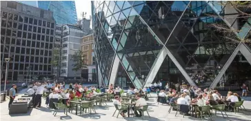  ?? — Bloomberg ?? Stopping infections: Customers dine at a restaurant outside 30 St Mary’s Axe in London. Hospitalit­y venues across England are set to close by 10pm from tomorrow, as ministers clamp down on socialisin­g in a bid to contain the spread of the coronaviru­s.