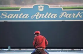  ??  ?? An outrider waits by the track as horses train for the Breeders’ Cup in 2014 at Santa Anita Park in Arcadia, Calif. JAE C. HONG/AP