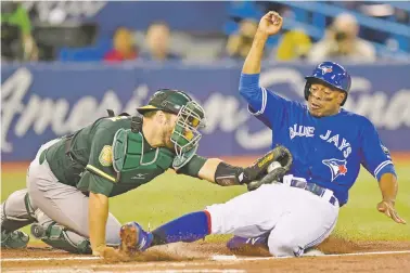  ?? FRANK GUNN/THE CANADIAN PRESS VIA AP ?? The Blue Jays’ Curtis Granderson, right, is tagged out at home plate by Athletics catcher Josh Phegley on Friday in Toronto.