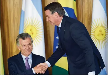  ??  ?? ENCUENTRO. Macri levanta la mano pero no lo mira. Mientras el argentino pareció más tibio y repitió intencione­s, el brasilero mostró tener un plan.