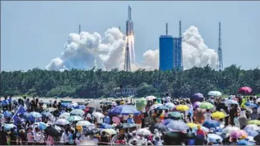  ?? LUO YUNFEI / CHINA NEWS SERVICE ?? Residents gather to witness the launch of a Long March 5B rocket in Wenchang, Hainan province, on July 24.