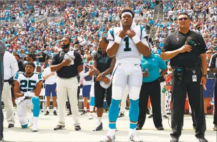  ?? Jason E. Miczek / Associated Press ?? Carolina Panthers safety Eric Reid kneels as head coach Ron Rivera, right, and Cam Newton stand during the national anthem before a game against the New York Giants in Charlotte, N.C., last Sunday.