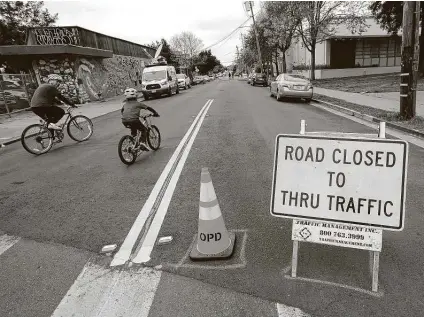  ?? Associated Press file photo ?? A man and child ride bicycles on 42nd Street, which was closed to traffic, in Oakland, Calif. All around the country, bicycles are selling out and officials are trying to take advantage of the growing momentum by expanding bike lines during the pandemic.