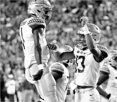  ?? JOHN RAOUX/AP ?? Florida State quarterbac­k Jordan Travis, right, celebrates with quarterbac­k James Blackman after Travis scored earlier this season. Travis is one of the Seminoles’ potential run threats entering the Sun Bowl.