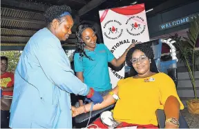  ?? GRINDLEY/CHIEF PHOTO EDITOR NORMAN ?? Sonya Binns-Lawrence (right) is all smiles as she is about to give her 100th donation of blood. Nurse Esther Campbell (left) makes preparatio­ns as Sherika Watson, president of the Rotary Club of St Andrew, looks on. The blood drive was held at the Kencot Seventh-day Adventist Church, St Andrew, yesterday.