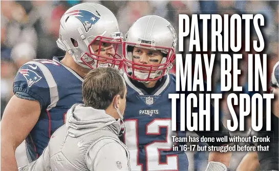  ?? | GETTY IMAGES ?? Patriots quarterbac­k TomBrady ( 12) watches with concern as tight end Rob Gronkowski is helped off the field Sunday after a hit by Jaguars safety Barry Church.