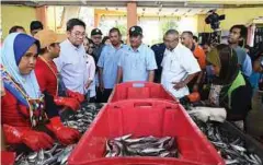  ??  ?? TIMBALAN Menteri Pertanian dan Industri Asas Tani, Sim Tze Tzin meninjau aktiviti penggredan ikan di Pelabuhan LKIM Tok Bali, Kelantan.