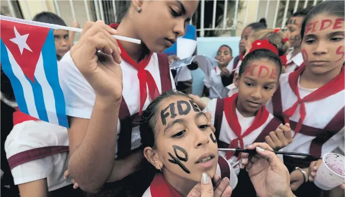  ??  ?? Adhesión.
Un grupo de jóvenes estudiante­s cubanos se pintan el rostro con el nombre de Fidel Castro, en el último día de los actos tras la muerte del fundador de la revolución.