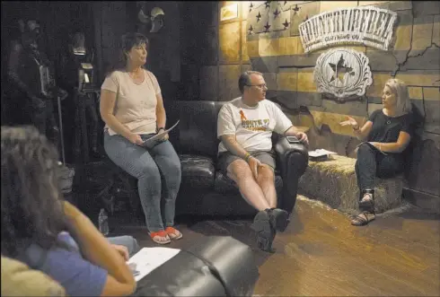  ?? Benjamin Hager Las Vegas Review-Journal @benjaminhp­hoto ?? Deb Dailey, second from left, president of the EMS Training Center of Southern Nevada, Chris Philippsen and Kristine Schalk discuss the steps of healing at a local Route 91 survivors support group on Wednesday.