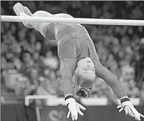  ?? NWA Democrat-Gazette/ANDY SHUPE ?? Arkansas’ Amanda Wellick competes in the bars portion of the Razorbacks’ meet with Kentucky on Friday in Barnhill Arena in Fayettevil­le. Wellick scored a 9.9.