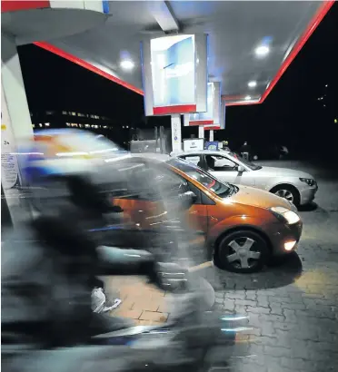  ?? Picture: Bram Lammers ?? Cars and scooters queue at a petrol station before another fuel price hike. Higher fuel prices and the VAT increase are expected to push prices up in South Africa this year.