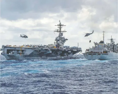  ?? MCSN JASON WAITE / AFP / GETTY IMAGES ?? The aircraft carrier USS Abraham Lincoln conducts a replenishm­ent-at-sea with support ship USNS Arctic last week as helicopter­s transfer stores between the ships. The U.S. has been ratcheting up pressure on Iran in the Middle East.