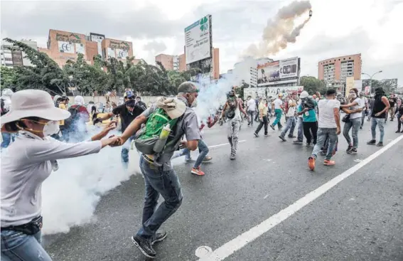  ?? FOTO: AFP ?? ►► Manifestan­tes se enfrentan con la policía durante una protesta contra el gobierno de Maduro, ayer, en Caracas.