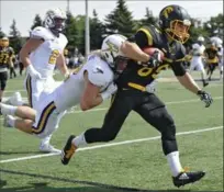  ?? IAN STEWART, SPECIAL TO THE RECORD ?? Waterloo Warriors receiver Blair McKay drags Laurier linebacker Brian Lowrance during the first quarter.