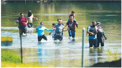  ?? Associated Press ?? A group of migrants mainly from Venezuela wade through the Rio Grande as they cross the U.S.-Mexico border Wednesday in Del Rio, Texas. Record numbers of Venezuelan­s are crossing the U.S.-Mexico border as overall migration swells.