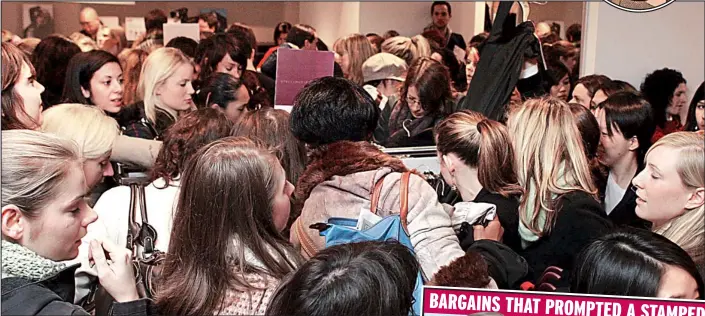  ??  ?? Snatch and grab: Shoppers elbow their way to the rails at H&M yesterday.