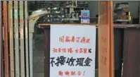  ?? LI FENG / FOR CHINA DAILY ?? Center: A notice stating “no cash during the pandemic due to the virus” is posted at the entrance to a store in Yichang, Hubei province.