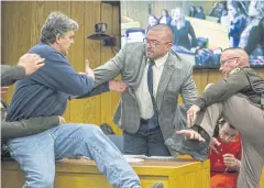  ??  ?? ‘YOU DEMON’: Randall Margraves, left, father of three victims of Larry Nassar, background right, lunges at Nassar in Eaton County Circuit Court in Charlotte, Michigan, on Friday.