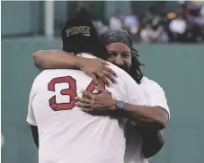  ?? AP PHOTO/STEVEN SENNE ?? Former Boston Red Sox’s Manny Ramirez (right) hugs former teammate David Ortiz (34) on the field during a pre-game ceremony held to present Ramirez with his Boston Red Sox Hall of Fame plaque before a baseball game against the Detroit Tigers, on June 20 in Boston.