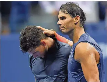  ?? FOTO: EMMERT/AFP ?? Der Spanier Rafael Nadal (rechts) tröstet den Österreich­er Dominic Thiem nach ihrem epischen Duell im Viertelfin­ale der US Open. Der Sieger steht erst nach 4:49 Stunden Spielzeit um 2.03 Uhr Ortszeit fest.