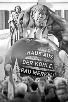  ??  ?? Protesters carry a paper caricature of German Chancellor Angela Merkel during a demonstrat­ion under the banner ‘Protect the climate - stop coal’ two days before the start of the COP 23 UN Climate Change Conference hosted by Fiji but held in Bonn,...