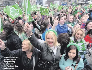  ??  ?? Annual parades: people wave flags during a previous St Patrick’s Day celebratio­n