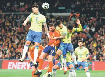  ?? — AFP photo ?? Brazil’s midfielder Paqueta (left) vies for a header with Spain’s defender Aymeric Laporte (centre) and Brazil’s midfielder Joao Gomesdurin­g the internatio­nal friendly match between Spain and Brazil at the Santiago Bernabeu stadium in Madrid. Spain arranged a friendly against Brazil at the Santiago Bernabeu under the slogan “One Skin” to help combat racism.