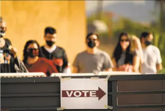  ?? Matt York / Associated Press 2020 ?? Voters wait to cast ballots at a polling station Nov. 3 in Mesa. Election officials throughout Arizona have found fewer than 200 cases of potential voter fraud in the presidenti­al election.