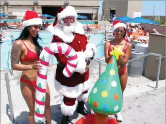  ?? WAYNE PARRY — THE ASSOCIATED PRESS ?? This photo shows casino employees bringing inflatable pool toys to Santa at the outdoor pool at the Ocean Casino Resort in Atlantic City, N.J.