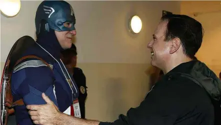  ?? Flávio Florido/Folhapress ?? João Doria cumpriment­a presidente de grupo de voluntário­s vestido com as roupas do personagem Capitão América