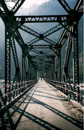  ??  ?? Clockwise from left: Ram Jhula, an old iron bridge that extends across the Ramganga River, is ideal for a leisurely stroll; the most breathtaki­ng stretch of the trekking route to Khaliya Top; a thin stream burbles amid tall deodar trees in the forests of Jageshwar Dham; the idyllic town of Almora is shaped like a horseshoe and surrounded by old oaks and tall pines.