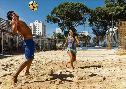  ?? Eduardo Knapp/Folhapress ?? O professor Bello Soares e a campeã paulista de 2019 Tatiana Pena jogam futevôlei na Zona Sul de São Paulo